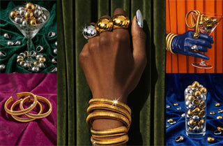 Elorae Jewelry and Accessories jewelry collage of Metropolis Coil Bangles, and Halo rings overflowing in martini glasses on green, orange, blue, pink and green curtain backgrounds.