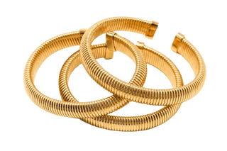 Stack of three Elorae gold Metropolis coil bangles on a white background.