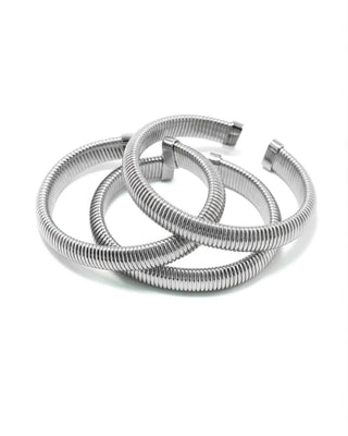 Elorae silver Metropolis Coil Bangles stacked on a white background.